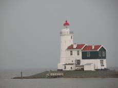 lighthouse building shore island grey stormy wooden white green red