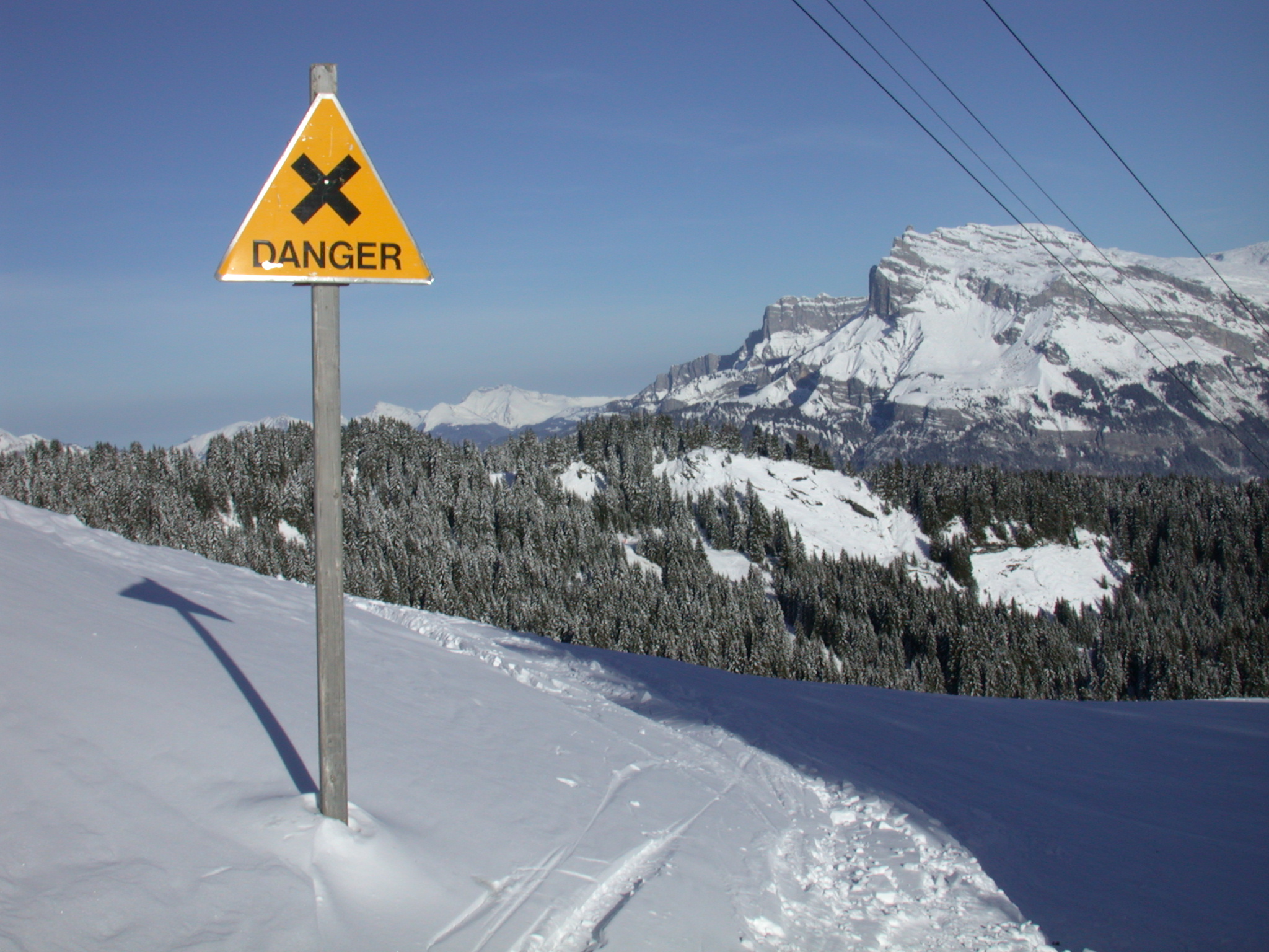 objects signs warning cross yellow snow wintersports mountainscape mountain mountains winter sports trees white