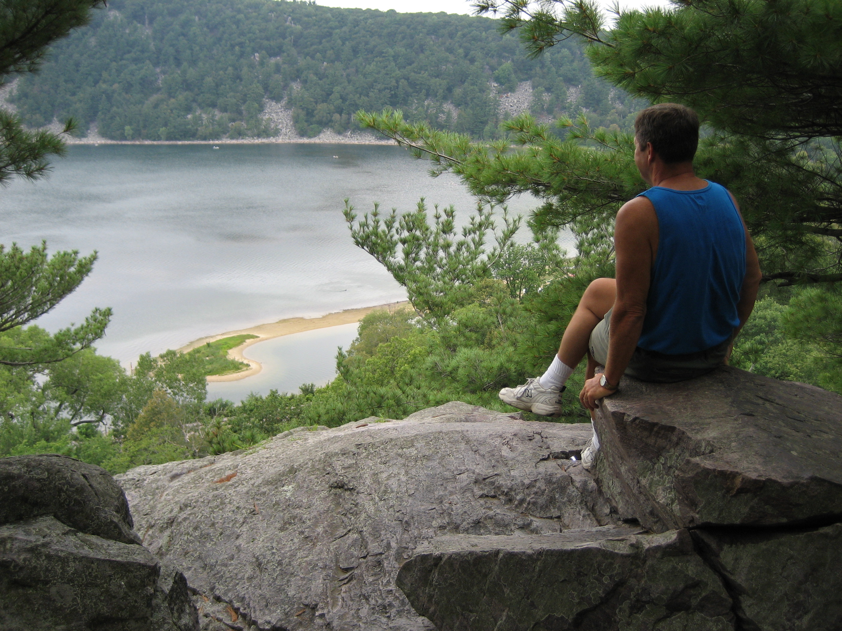 gallagher_lucas man looking over a lake trees rock sitting relaxing royalty free