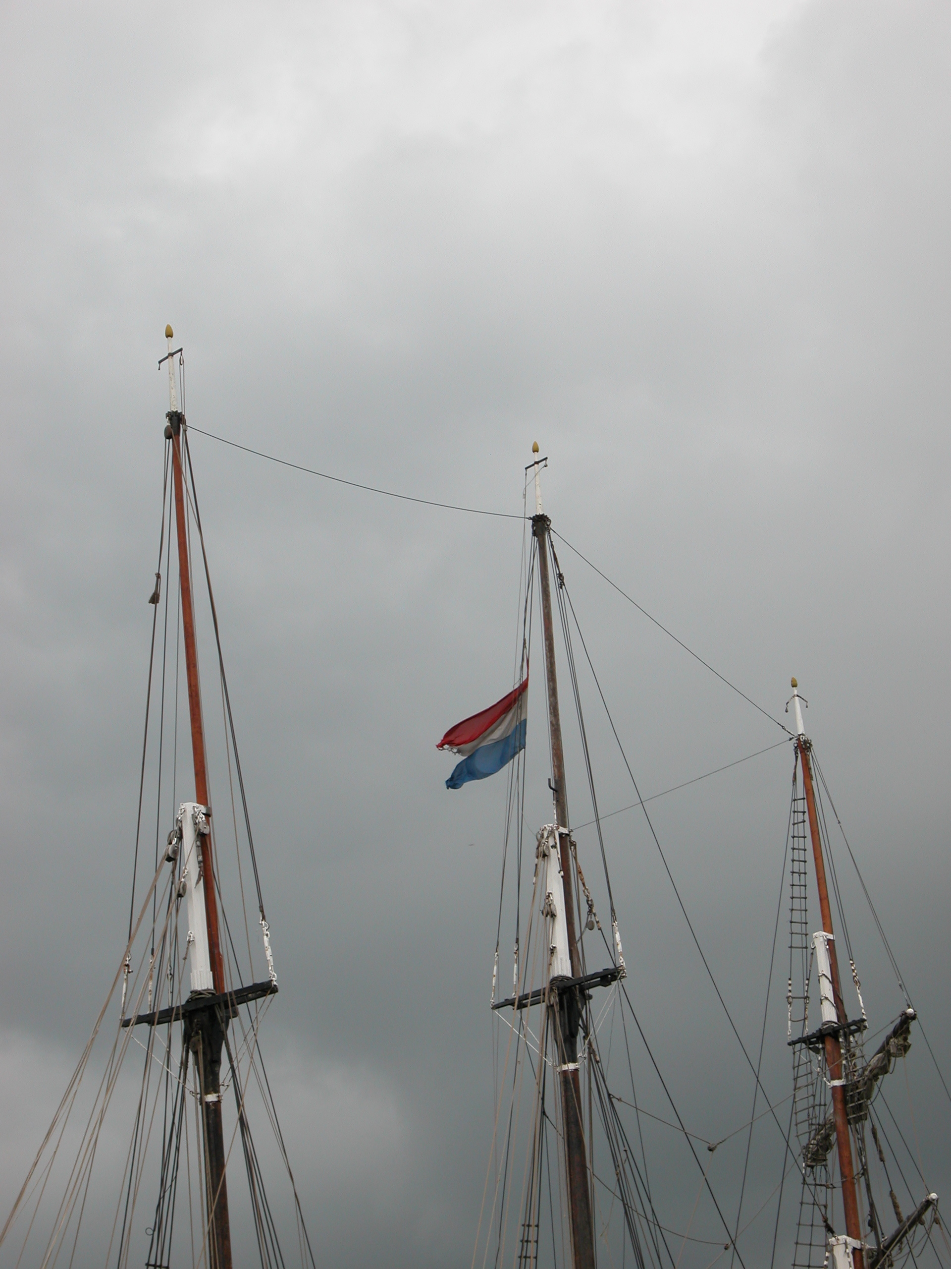 masts ships boats sky dark cloud