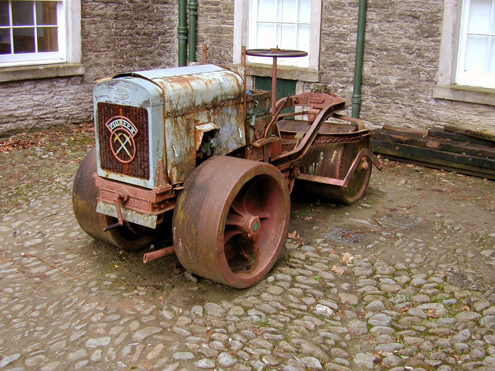 roadroller roller road rust metal old vehicle wheel lever handle cobstones aqua grill courtyard perkins logo