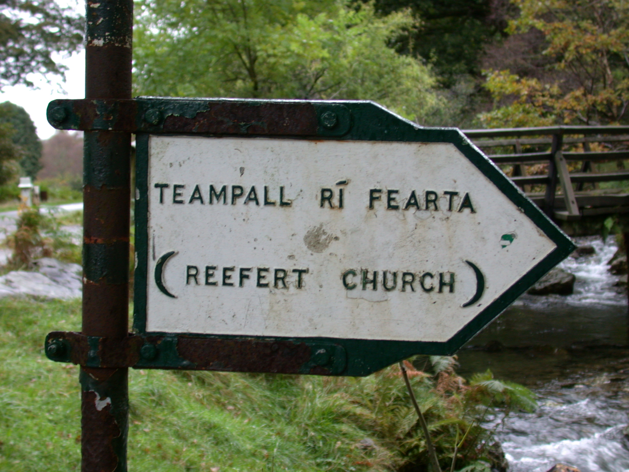 road sign roadsign pointing direction directions church reefer black and white teampall ri fearta brook stream country countryside country-side