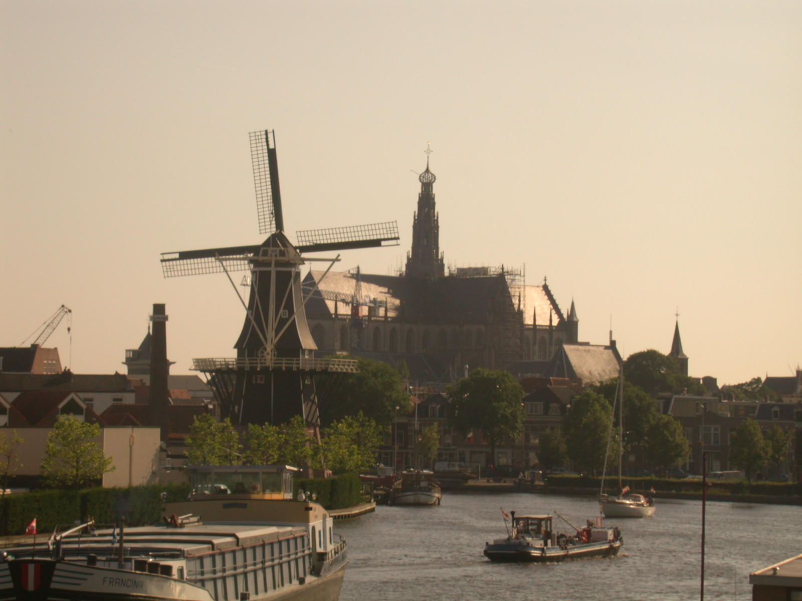 nature landscapes cityscapes haarlem river riverscapes waterscapes traffic boat boats ship architecture exteriors mill windmill cathedral church houses city summer